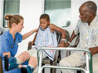  ?? PHOTOS: SAUL LOUBASSA/MERCY SHIPS ?? Fropm left, Upper Hutt nurse Josie Christense­n helps her patient, Justine, deal with the aftermath of orthopaedi­c surgery to straighten her legs.