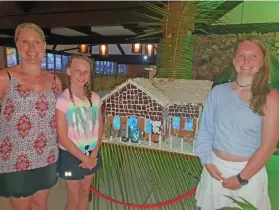  ?? Photo: Nicolette Chambers ?? From left: Kim Rogers, Tara Rogers and Nikita Rogers beside the gingerbrea­d house created by the staff of Plantation Island Resort.