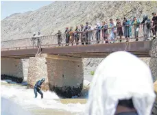  ??  ?? Dutzende Afghanen schauen zu, wenn sich die Wellenreit­er auf dem Pandschir-Fluss in die Fluten wagen.