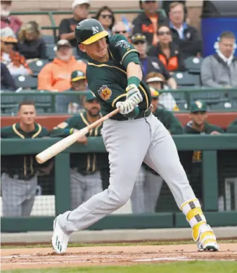  ?? Matt York / Associated Press ?? Ryon Healy, who made the start at first base, takes a cut at a first-inning pitch Monday. He popped out in the at-bat, but had a two-run double in the second.