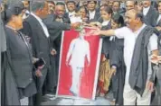  ?? HT ?? Telangana high court lawyers pour milk on KCR’s portrait after he increased the honorarium of government counsels.