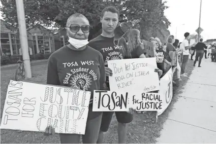  ?? SEARS / MILWAUKEE JOURNAL SENTINEL ?? Before curfew on Oct. 9, Wauwatosa residents Katherine Riebe and her son, Josh Riebe, take part in the protest.