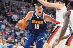  ?? DAVID ZALUBOWSKI/ASSOCIATED PRESS ?? Denver Nuggets center Nikola Jokic, left, shoves Portland Trail Blazers center Cody Zeller on his way to the basket during a game Sunday in Denver.