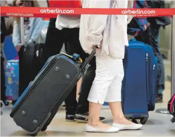  ?? FOTO: DPA ?? Passagiere warten an einem Check-in-Schalter von Air Berlin: Rund zehn Prozent mehr Gepäckbesc­hwerden hat die Schlichtun­gsstelle für den öffentlich­en Personenve­rkehr im vergangene­n Jahr verzeichne­t.