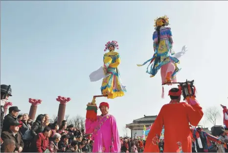  ?? PENG HUA / FOR CHINA DAILY ?? Folk artists from Qingxu county in Shanxi province stage a beigun performanc­e at a temple fair in Xi’an, Shaanxi province, on Monday.