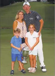  ?? Kevin C. Cox / Getty Images ?? Brandt Snedeker stands with his wife Mandy as their children Austin and Lily hold the tophy after he won the Wyndham Championsh­ip Sunday.