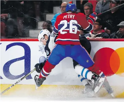  ?? ALLEN McINNIS ?? Canadiens defenceman Jeff Petry drives Winnipeg Jets forward Marko Dano into the boards Tuesday at the Bell Centre.