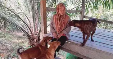  ??  ?? ZALINA bersama anjing peliharaan di dusun durian miliknya.