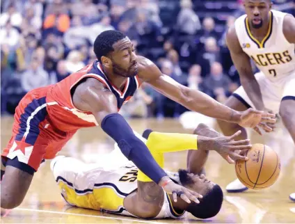  ?? AP FOTO ?? GROUND
BATTLE. John Wall fights Myles TUrner for the loose ball during their final NBA game before the All-Star break.