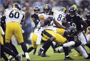  ?? NICK WASS - THE ASSOCIATED PRESS ?? Pittsburgh Steelers running back Najee Harris (22) is hit by Baltimore Ravens safety Chuck Clark (36) while rushing for yardage during the first half of an NFL football game, Sunday, Jan. 9, 2022, in Baltimore.