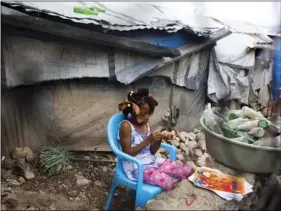  ??  ?? Seven-year-old Ducler Sarah Roudencia sharpens her pencil while she studies her lesson in the Caradeux refugee camp set up nearly eight years ago for people displaced by the 2010 earthquake, in Port-au-Prince, Haiti on Thursday. Haitians reacted with...