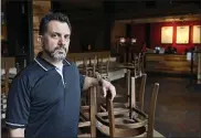  ?? SUE OGROCKI — THE ASSOCIATED PRESS ?? JJ Kuhn, general manager of Yucatan Taco Stand Tequilla Bar and Grill, poses in the empty dining room at the restaurant March 27in Oklahoma City.