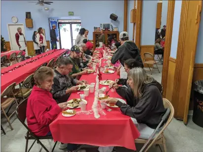  ?? PHOTOS BY JAKE HUTCHISON — ENTERPRISE-RECORD ?? Families and friends gather at large tables to enjoy a dinner together Wednesday at the Oroville Aerie FOE building.