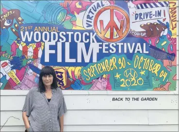  ?? TANIA BARRICKLO — DAILY FREEMAN FILE ?? Meira Blaustein, executive director of the Woodstock Film Festival, stands in front of a festival banner outside The Golden Notebook bookstore on Tinker Street in Woodstock, N.Y. on Sept. 9.