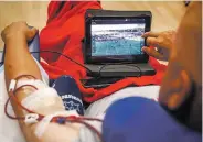  ??  ?? Gonzalez watches game film during his dialysis treatments.