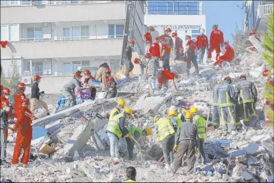  ?? Darko Bandic The Associated Press ?? Rescue crews search for survivors Saturday in the debris of a collapsed building in Izmir, Turkey. Hundreds of aftershock­s rattled the area in the wake of the powerful earthquake Friday that struck the Aegean coast and north of the Greek island of Samos, killing dozens.