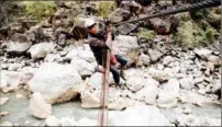  ?? CHEN WUSHUAI / FOR CHINA DAILY ?? A villager in Haila, a town in Guizhou, takes a zip line to cross the Niulan River in March 2019.