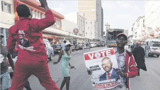  ?? Picture: AFP ?? CHANGE IS HERE. Supporters of MDC Alliance leader Nelson Chamisa cheer outside the party headquarte­rs in the capital Harare yesterday.
