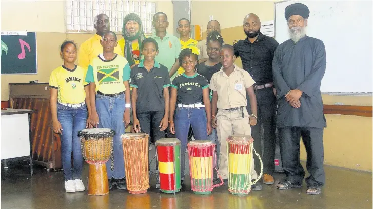  ??  ?? Backrow, from left: acting vice-principal Raphael Davis, musician Anthony Postman, master drummer Maroghini, musical director Wayne Davis and some of the music students at Jessie Ripoll Primary School in Kingston posing with drums that were donated to the school by American vocalist Marissa Lelogeais.