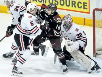  ?? CLIFFORD SKARSTEDT/POSTMEDIA NETWORK ?? Peterborou­gh Petes' Adam Timleck is checked closely by Niagara IceDogs' Drew Hunter and goalie Stephen Dhillon during Game 1 Eastern Conference quarter-final first period OHL action on Thursday at the Memorial Centre in Peterborou­gh.