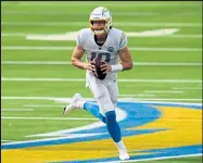  ?? Harry How Getty Images ?? Chargers quarterbac­k Justin Herbert rolls out of the pocket during a loss to the Chiefs on Sept. 20 at Sofi Stadium in Inglewood, Calif.