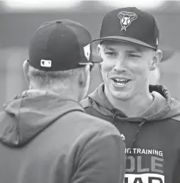  ?? ROB SCHUMACHER/THE REPUBLIC ?? Arizona Diamondbac­ks first baseman Jake Lamb talks to manager Torey Lovullo during spring training workouts on Monday at Salt River Fields near Scottsdale.