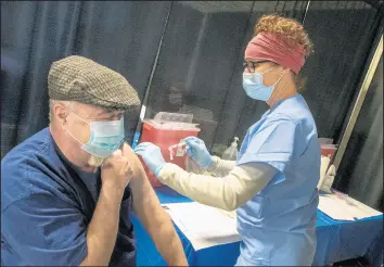  ?? ANDY LAVALLEY/POST-TRIBUNE ?? Registered nurse Lu Hoyt gives the first round of COVID-19 vaccine to Robert Murray, 68, of Wheatfield, at the clinic set up Friday at the Porter County Fairground­s.