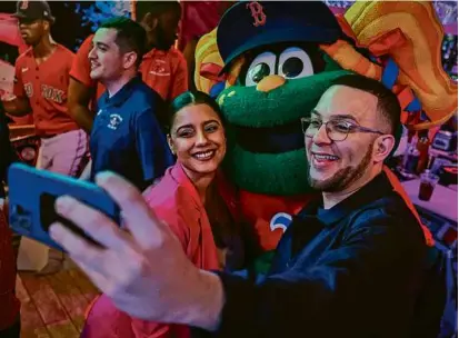  ?? PHOTOS BY ERIN CLARK/GLOBE STAFF ?? Lawrence City Councilor Stephany Infante and School Committee VP Jonathan Guzman with Sox mascot Tessie at the party.