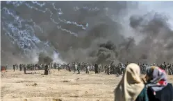  ?? HOSAM SALEM/NEW YORK TIMES ?? Tear gas and smoke mix Monday near protesters along the Gaza border with Israel. A mass attempt by Palestinia­ns to cross the border fence separating Israel from Gaza turned violent, as Israeli soldiers responded with rifle fire.