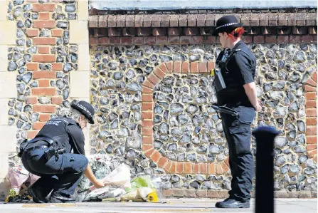  ?? REUTERS ?? A police officer lays flowers near the scene of reported multiple stabbings in Reading, Britain.