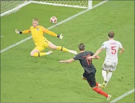  ?? Jewel Samad Getty Images ?? CROATIAN FORWARD Mario Mandzukic, center, scores the game-winning goal four minutes into the second extra-time period against England.