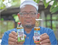  ?? ?? Aziz shows the massage oil he produced using rabbit fat.