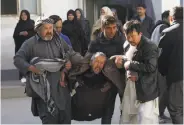  ?? Rahmat Gul / Associated Press ?? A distraught man is carried after a suicide attack by the Islamic State that hurt more than 80 people.