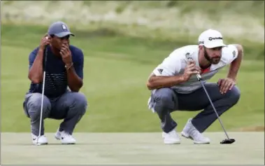  ?? SETH WENIG — THE ASSOCIATED PRESS ?? Tiger Woods, left, and Dustin Johnson line up their putts on the 16th green during the first round of the U.S. Open.