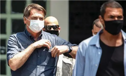  ??  ?? Brazil’s president, Jair Bolsonaro (left), leaves after voting during municipal elections in Rio de Janeiro. Photograph: Luis Alvarenga/Getty Images