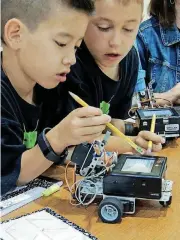  ?? [PHOTO PROVIDED BY NORMAN PUBLIC SCHOOLS] ?? Two students from Truman Elementary School in Norman look at programmin­g for their robots during a 2016 class.