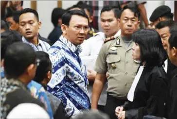  ?? BAY ISMOYO/AFP ?? Christian Governor Basuki Tjahaja Purnama (centre) speaks to his lawyers after judges delivered the verdict in his blasphemy trial in Jakarta yesterday.