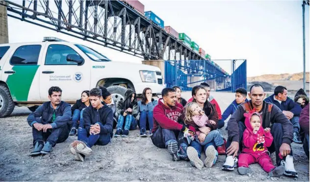  ?? Agence France-presse ?? A group of Brazilian migrants sits near the US Border Patrol agents in Sunland Park, recently.