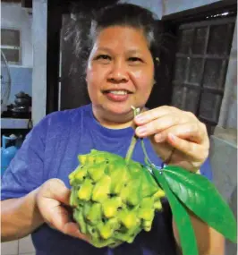  ??  ?? Nilda Montilla showing Cherimoya fruit from the Sarian Farm.