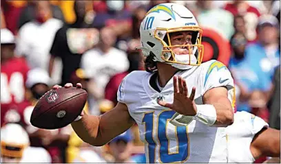  ?? ANDREW HARNIK / AP ?? Chargers quarterbac­k Justin Herbert (10) throws a pass against the Football Team during the first half of Sunday’s game in Landover, Md.