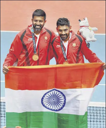  ?? AFP ?? India's gold medallists Rohan Bopanna (left) and Divij Sharan defeated Kazakhstan’s Aleksandr Bublik and Denis Yevseyev in the men’s doubles final in Palembang on Friday.