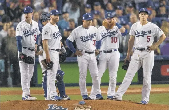  ?? Gina Ferazzi Los Angeles Times ?? DODGERS manager Dave Roberts, along with the infielders and catcher Austin Barnes, waits for Brandon Morrow to come out of the bullpen to relieve Yu Darvish.