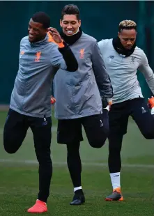  ??  ?? Liverpool players (l-r) Georginio Wijnaldum, Roberto Firmino and Nathaniel Clyne go through their stretching routine at Melwood yesterday