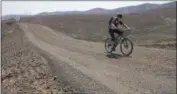  ?? THE ASSOCIATED PRESS ?? Warren Hurley rides his bike across a reconstruc­ted section on the John Wayne Trail on the Yakima Training Center, near Kittitas, Wash., on Friday.