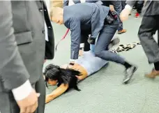  ?? Foto: Jan Zátorský, MAFRA ?? Lež Policista nasazuje aktivistce na zemi pouta.