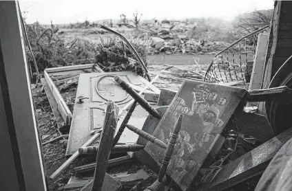  ?? Michael Clubb / Associated Press ?? A family photo lays among the debris inside of a house Sunday in Dawson Springs, Ky. Tornadoes tore through multiple states Friday night, including Arkansas, Illinois, Kentucky, Mississipp­i, Missouri and Tennessee.