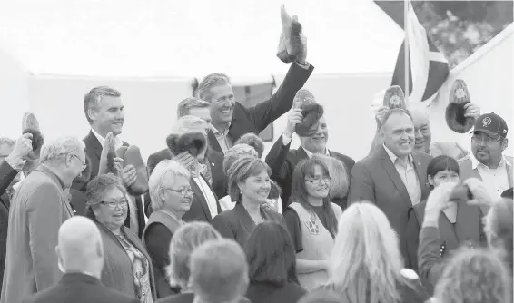  ?? JONATHAN HAYWARD, THE CANADIAN PRESS ?? Premiers hold up moccasins that were given to them by indigenous elders during a meeting in Whitehorse, Yukon, on Thursday.