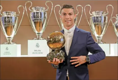  ?? ANGEL MARTINEZ / L’EQUIPE / AFP ?? Cristiano Ronaldo poses with the Ballon d’Or in the Trophy Room at Santiago Bernabeu stadium in Madrid. Winning the award as global soccer’s best player for the fourth time capped a terrific year for the Real Madrid star.