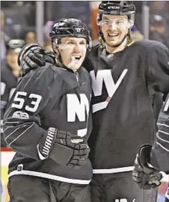  ?? AP ?? Islanders defensemen Scott Mayfield (r.) celebrates with Casey Cizikas after Cizikas’ second-period goal in Sunday’s victory over Devils.
