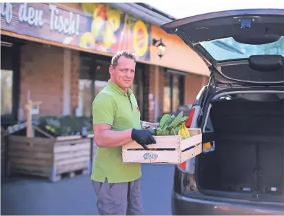  ?? RP-FOTO: ACHIM BLAZY ?? Drive-In am Hofladen im Schwarzbac­htal: Verkäufer Matthias Orb lädt die bestellten Sachen in den Kofferraum ein.